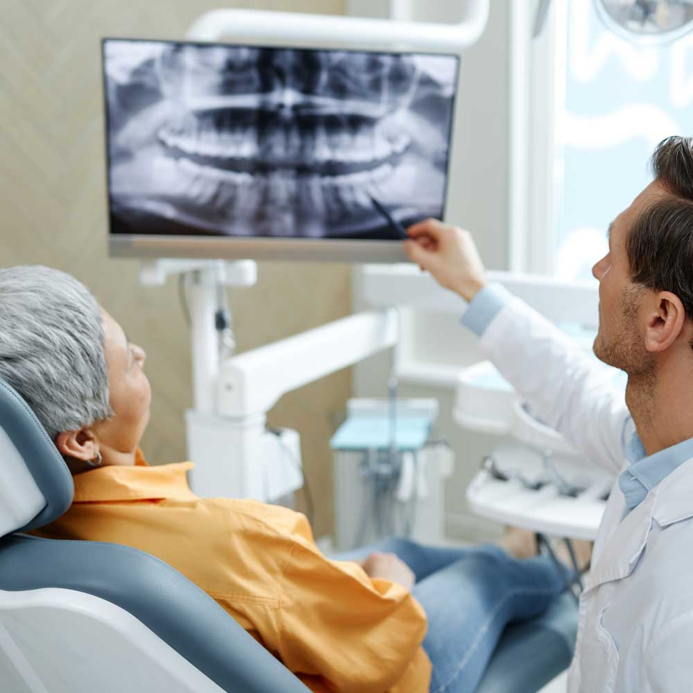 Patient and dentist looking at dental x-ray