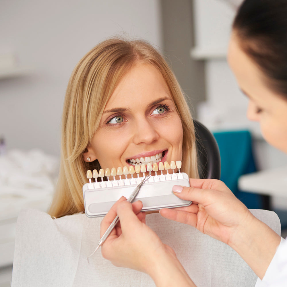 Teeth whitening - dentist measuring the shade of a patient's teeth